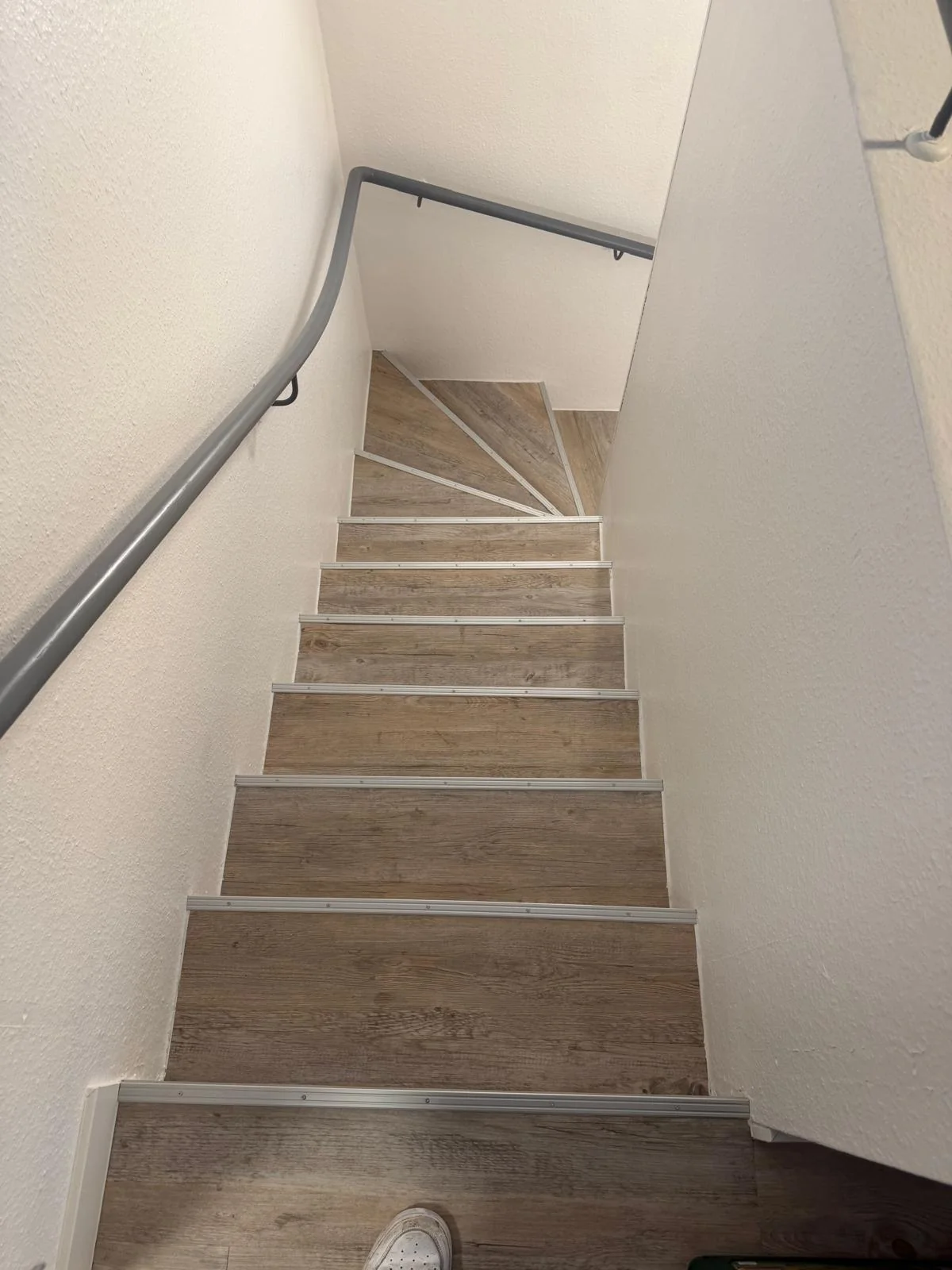 Treppe mit Bodenbelag in Holzoptik und Kantenprofilen